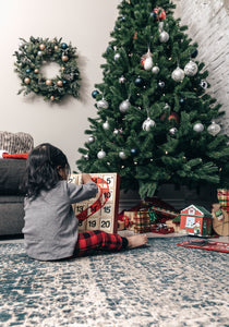 Little girl in front of Christmas tree with ornaments