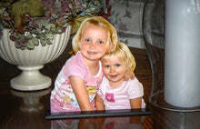 Load image into Gallery viewer, Two young girls as a photo statuette sitting on a coffee table.
